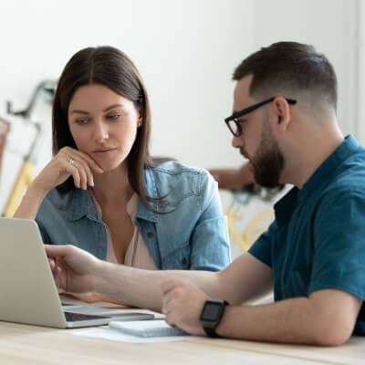 Shot of a man and woman going through paperwork and using a laptop together
